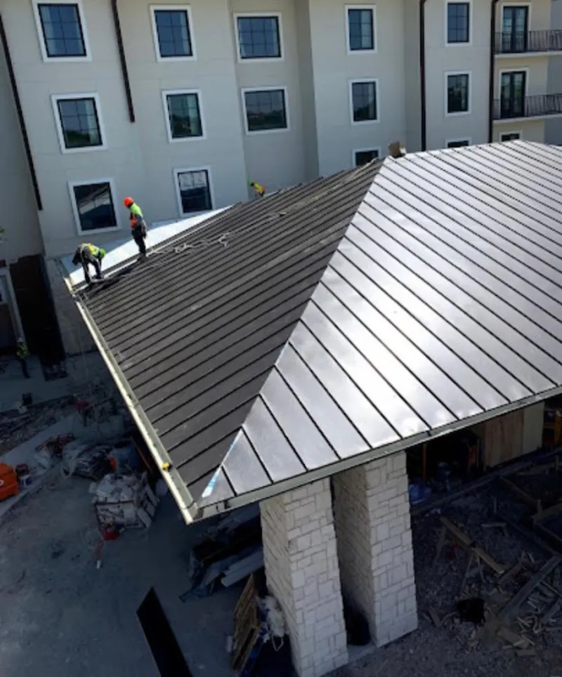 Crew installing standing seam metal roof panels on a commercial project in Lower Gwynedd